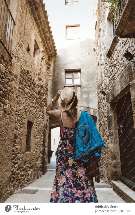 Woman walking in a narrow path in a village Fashion Hat Lifestyle Exterior shot Human being Street Style Summer Europe Tourism Tourist Town Vacation & Travel