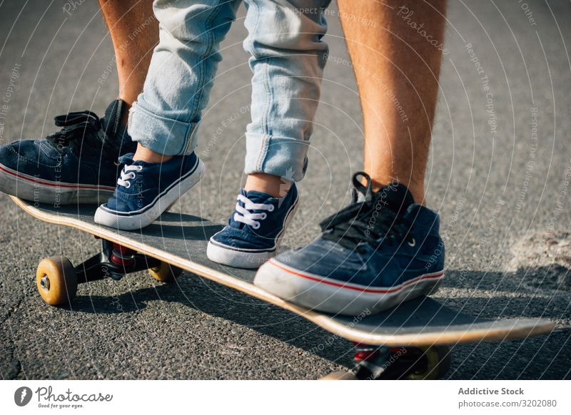 Man with kid training with skateboard on asphalt Father Child Skateboard enjoying parenthood Walking Vacation & Travel Family & Relations teaching Together Joy
