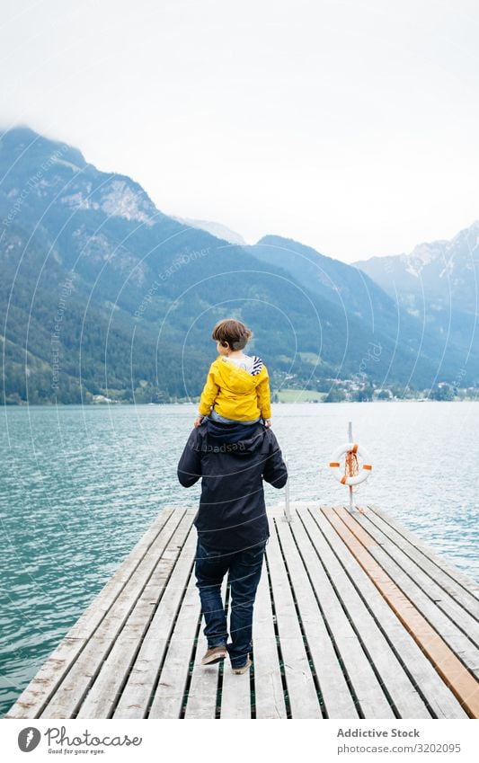 Man with kid on neck walking along pier Father Child parenthood Landscape Jetty Walking Nature Vacation & Travel Family & Relations Together Mountain