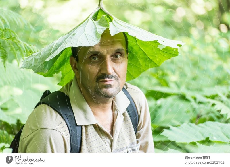 A man put a green leaf on his head in nature Lifestyle Style Masculine Man Adults 1 Human being 45 - 60 years Culture Environment Nature Plant Summer Forest Hat