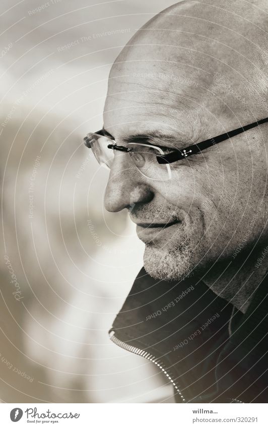 Man with glasses, bald head and three day beard smiles, profile Person wearing glasses Eyeglasses Bald or shaved head Designer stubble Smiling Contentment