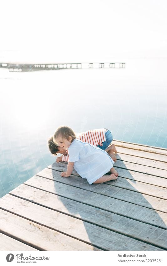 Curious kids on pier Child Strange seascape Jetty Together Observe Cute Baby sibling Boy (child) Girl Charming Sit Vacation & Travel Family & Relations Brother