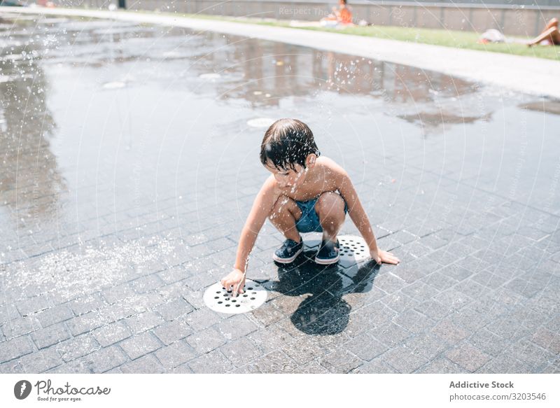 Kid standing in jet of fountain on street Boy (child) Fountain Street Jet Summer Float in the water Stream Water Park Joy Vacation & Travel Town Stand Fresh
