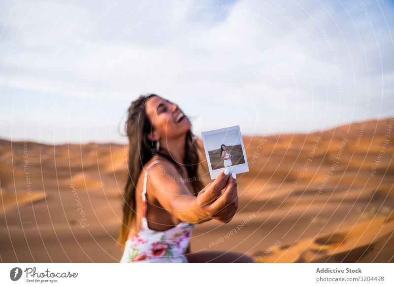 Happy woman showing instant photo in desert Woman Photography Vacation & Travel Desert Indicate Morocco Joy Cheerful Shot Illustration self Frame Nature Heat