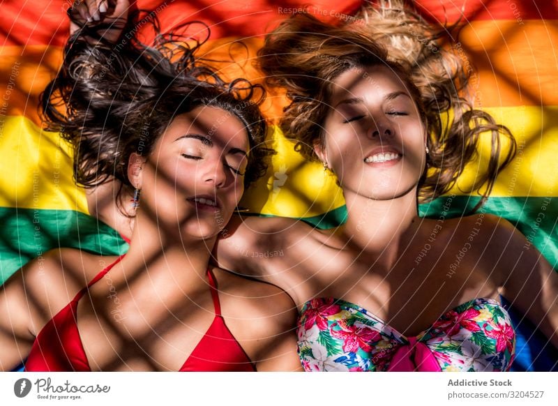 Lesbian couple lying on rainbow flag Couple Homosexual lgbt Flag Closed eyes Laughter Woman Youth (Young adults) Lifestyle Leisure and hobbies Rest Relaxation