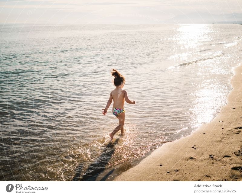 Anonymous girl running on seaside Girl Running Beach Swimming & Bathing Ocean Splash Child Sand Calm Playing Infancy enjoying Action Summer Toddler
