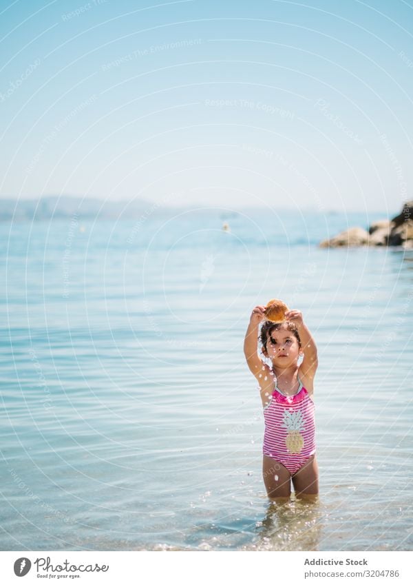 Cute girl playing in water of seaside Girl Water Playing seashell Toddler Delightful Ocean swimming suit Warmth Beach Sunbeam Infancy Swimming & Bathing