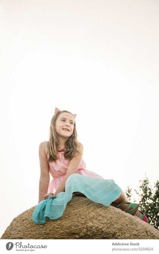 Dreamy cute girl sitting on rock Girl Nature Child Summer Infancy Cute Dress Beautiful Beauty Photography Sit Contemporary explore Innocent Smiling Rock Sky