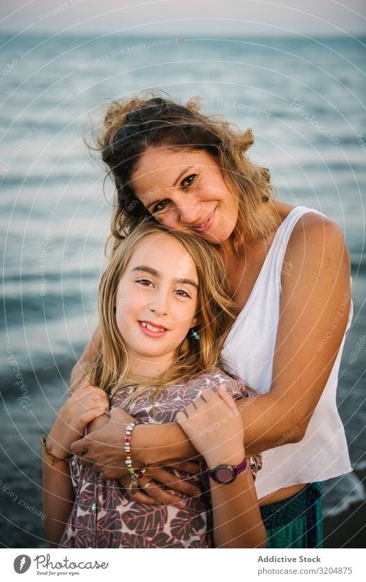 Beautiful mother and daughter embracing on beach Woman Daughter Beach Embrace Love Happy Beauty Photography Mother Family & Relations Together Child Style Ocean