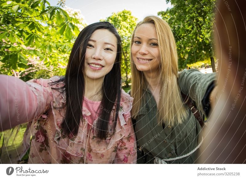 Multiracial friends taking selfie in park Friendship Selfie Park Smiling Mixed race ethnicity Together Youth (Young adults) Woman Lifestyle Leisure and hobbies