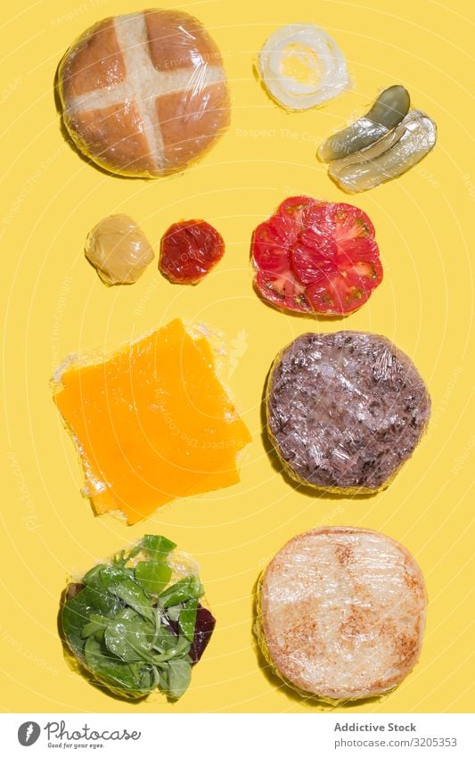 Ingredients of a cheese burger wrapped in plastic Barbecue (event) BBQ Beef Bread Roll Cheese Conceptual design flat lay Food Hamburger Ketchup Lettuce Meat
