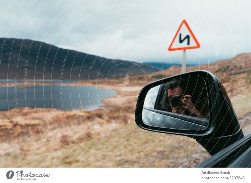 Traveling photographer with camera in car man travel photography mirror landscape scotland self transport lake mountain remote automobile journey window vehicle