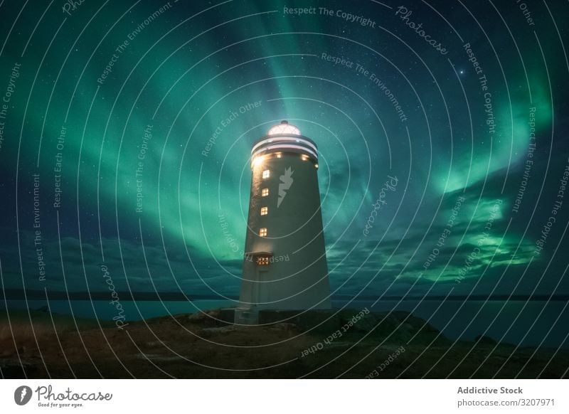 Lighthouse against starry sky in winter countryside lighthouse night stars northern lights borealis aurora snow landscape landmark beacon bright cloudless polar