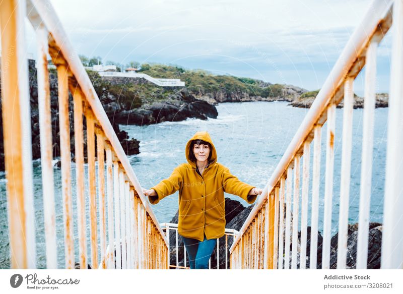 Woman standing on steps near sea woman shore stairway bay waves water rusty railing travel female trip tourism journey casual coast ocean storm weather grungy