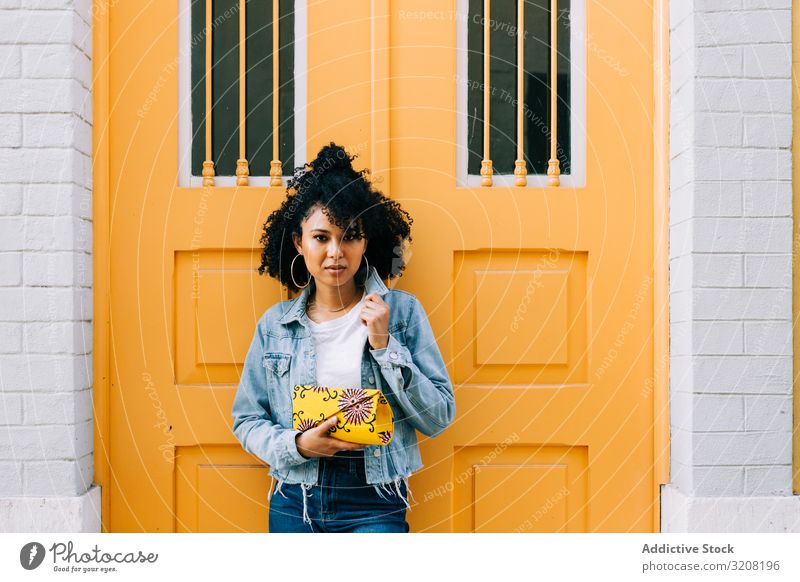 Stylish ethnic female by yellow door woman arch stylish trendy architecture travel tourism destination young african american casual pensive attractive