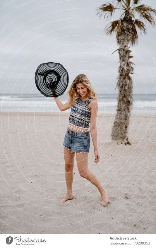 Young female relaxing on beach with hat woman fashionable summer vacation travel recreation holiday resort young person attractive slim beautiful playful blonde