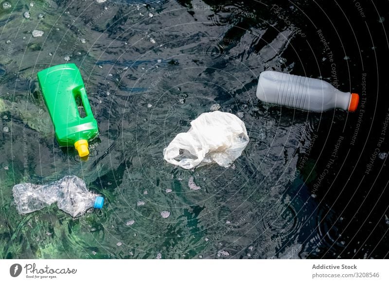 Plastic bottles and bag floating on water pollution plastic rubbish environmental ecology toxic recycling dangerous nature global world damage problem issue bio