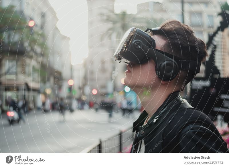 Young man wearing glasses of virtual reality on street vr urban millennial lifestyle technology cyber device imagination experience entertainment male enjoyment