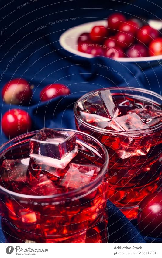 Red beverage near fresh fruits on cloth red glass fabric cold cocktail plum ice portion cubes drink summer refreshment juice food healthy alcohol cherry cool