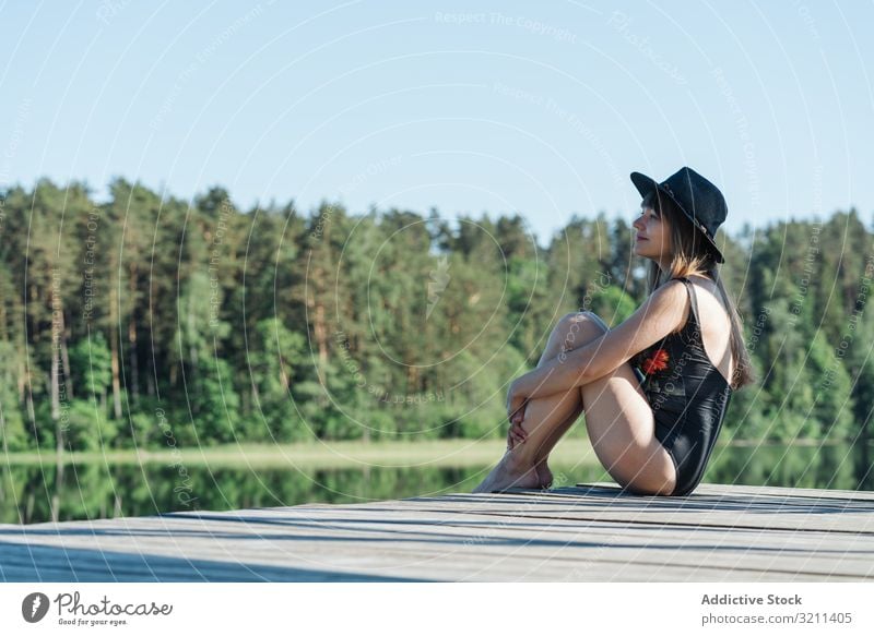 Young female sitting on pier on nature woman admiring lake freedom travel tourism rest adventure forest tourist picturesque young happy joy rural scenic view