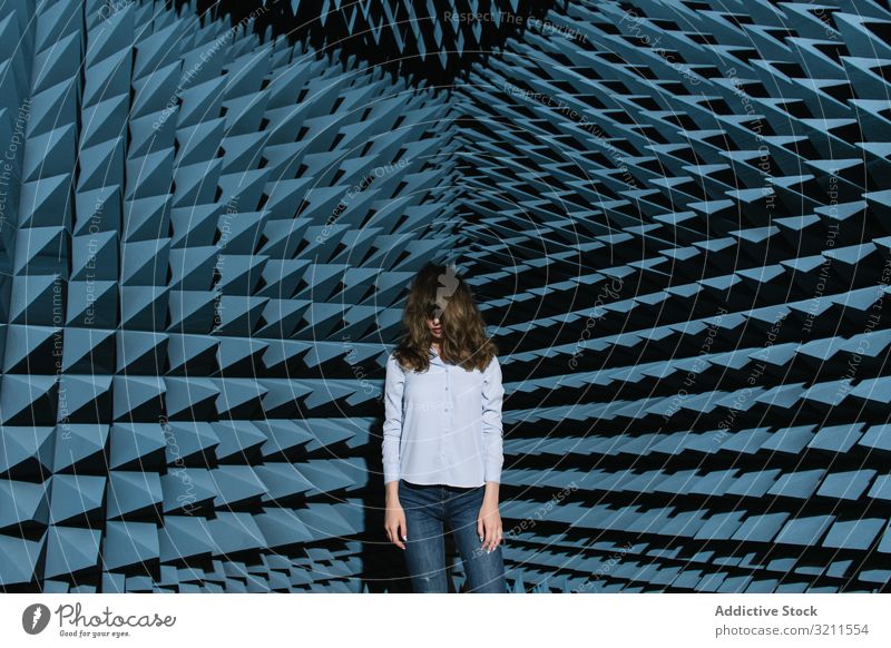 Woman in middle of sound room shaking head woman music enjoy covering face modern beautiful entertainment contemporary unusual soundproof standing young female