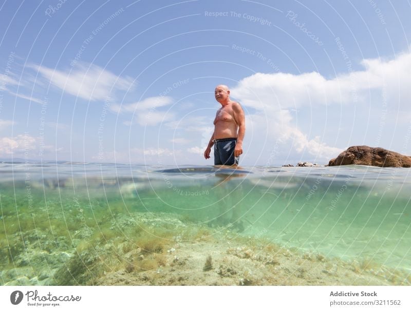 Cheerful elderly man swimming in sea water vacation senior crystal retired travel leisure greece halkidiki ocean mature happy floating nautical summer enjoy