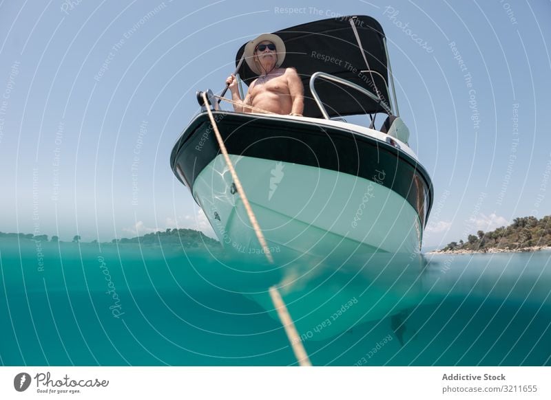 Man sailing in boat in clear turquoise water man yacht elderly vacation summer nautical travel sea luxury leisure halkidiki sailor greece freedom traveler