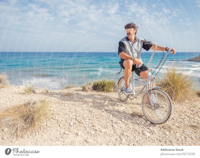 Man cycling on sandy beach hill man bike seaside vacation happy summer wave active lifestyle holiday trip energetic travel journey male offroad terrain freedom