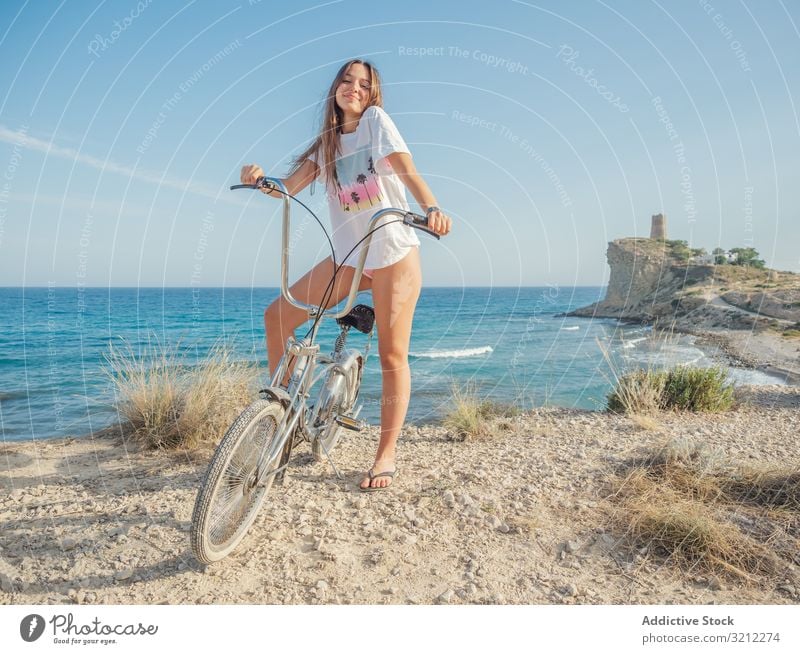 Woman cycling on sandy beach hill woman bike seaside vacation happy summer wave active lifestyle holiday trip energetic travel journey young female offroad
