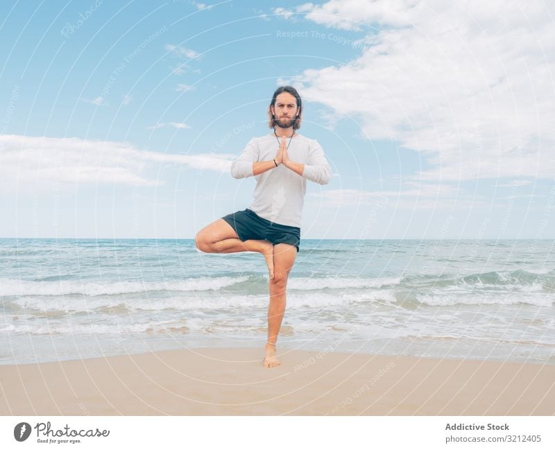 Man training yoga on beach man rest harmony asana exercise seashore energy meditation equilibrium stretch zen relax balance sport lifestyle calm male bearded