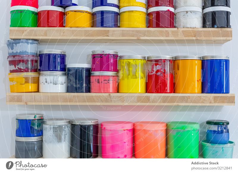 Shelves with colorful tins of paint shelf workshop art vivid row spectrum occupation colour different size shape creativity artist hobby lifestyle drawing