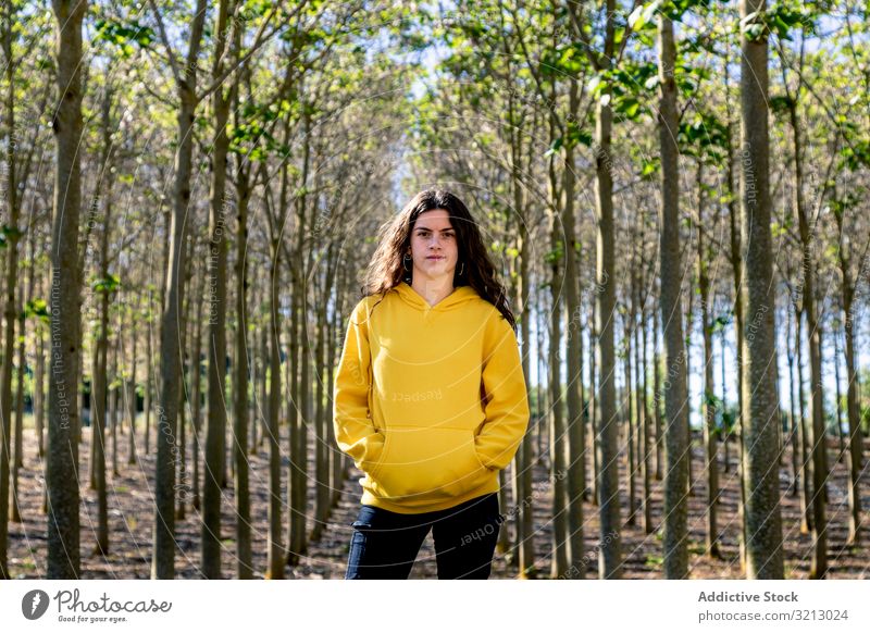Pretty sportive girl standing in forest sweatshirt walk adventure tourism travel teenager female young person brunette beautiful serious pensive thoughtful