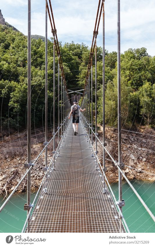 Man crossing a bridge in the mountain man suspension nature person green travel landscape outdoor adventure walk trekking hiking young people tourism river