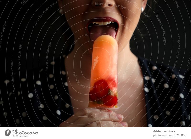Woman eating fruit popsicle with berries woman berry fresh food lick sensual dessert homemade colorful cool sweet cold ice tasty sorbet natural stick snack
