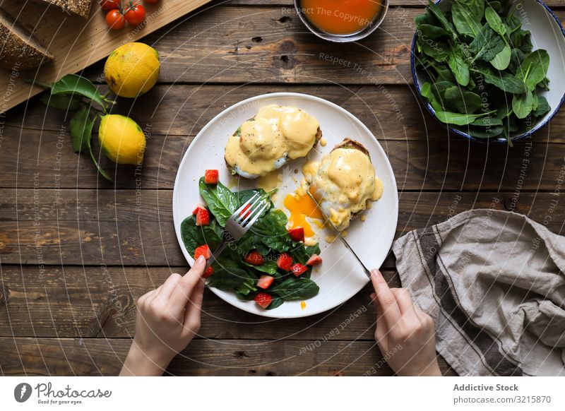 Person eating scrambled eggs on bread with green sauce and tomato meal tasty food breakfast plate delicious table homemade organic cutlery nutrition vegetable