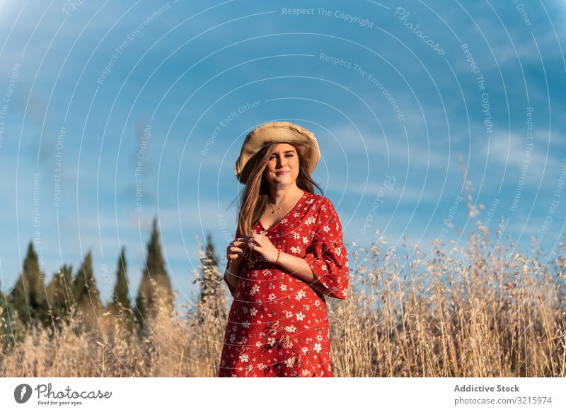 Happy dreamy woman standing among high grass field happy attractive smiling straw hat red dress blue sky nature summer young lifestyle positive happiness