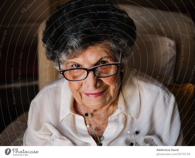 Portrait of aged female in white shirt at home woman grandmother experience wisdom attention grandparent generation senior elderly wrinkle granny gray haired