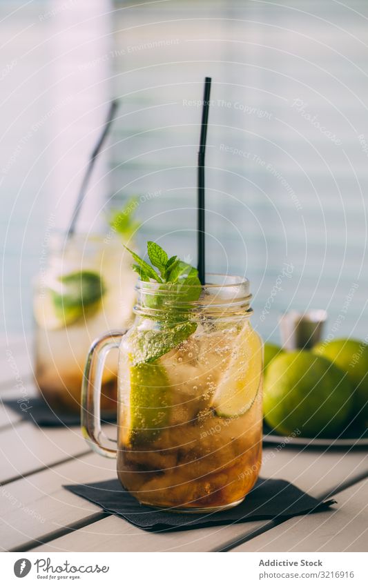 two Mojitos in mason jar on wooden table alcohol background barman bartender beverage bokeh cocktail cold drink food fresh garnish ice lime mint mixologist