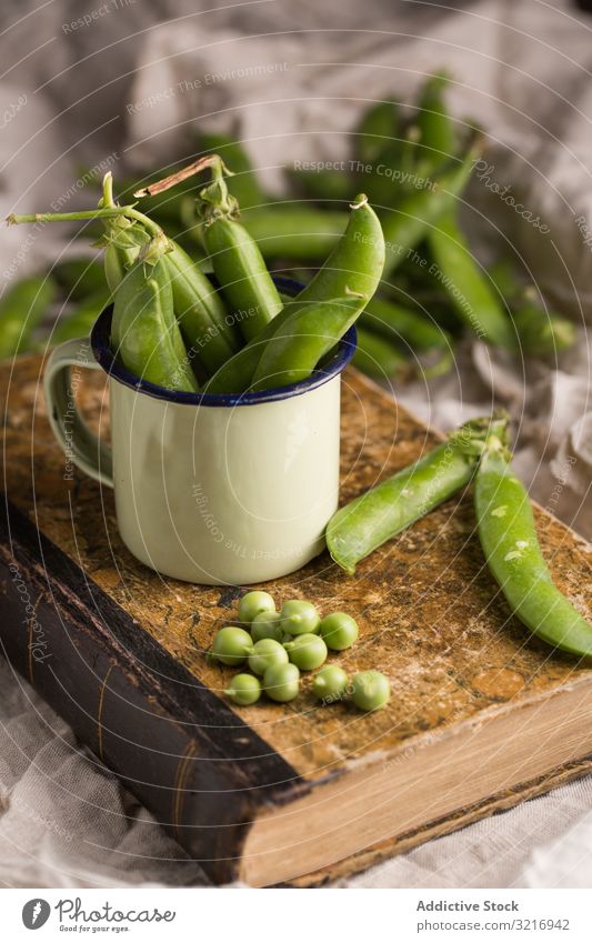 Fresh peas and pea pods bowl cup ecological food fresh green healthy legume natural organic raw seed vegetable vegetarian white cream wooden plant towel salt