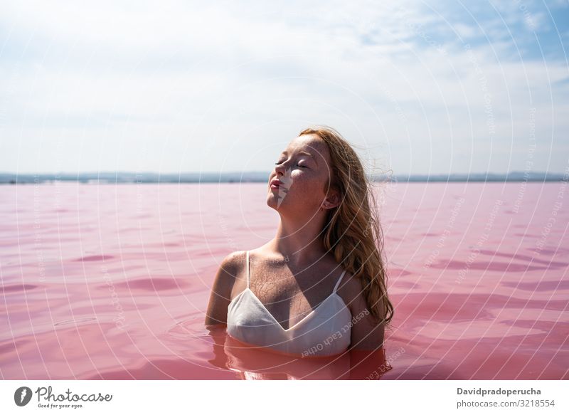 cute teenager girl wearing white dress in the water of an amazing pink lake woman stroll salty harmony mood romantic peace relax rest natural torrevieja