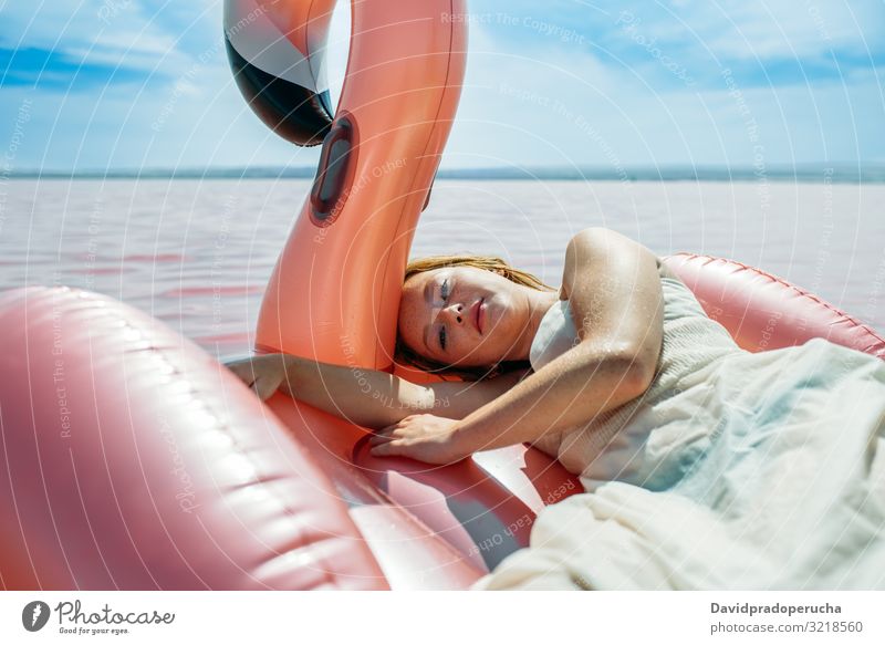 Beautiful woman lying on inflatable float mattress on pink sea female beach relax nature beautiful sunny cute young paradise salt halobacteria Spain water