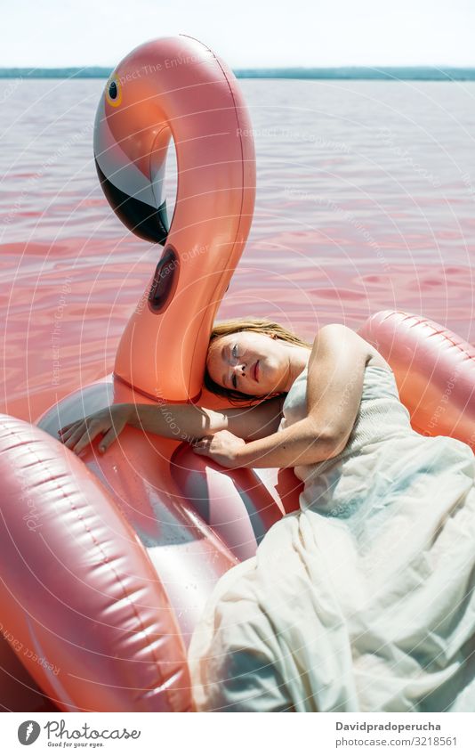 Beautiful woman lying on inflatable float mattress on pink sea female beach relax nature beautiful sunny cute young paradise salt halobacteria Spain water