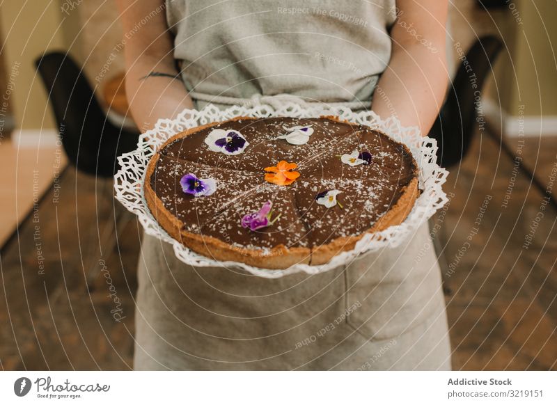 Brown pie decorated with flowers in woman hands cake homemade sweet bakery gourmet organic nutrition tasty appetizing refreshing raw delicious holiday