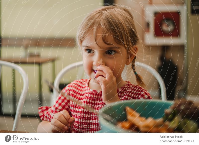 Girl eating with hand from blue bowl girl gourmet homemade organic nutrition tasty refreshing raw adorable delicious yellow holiday innocence traditional