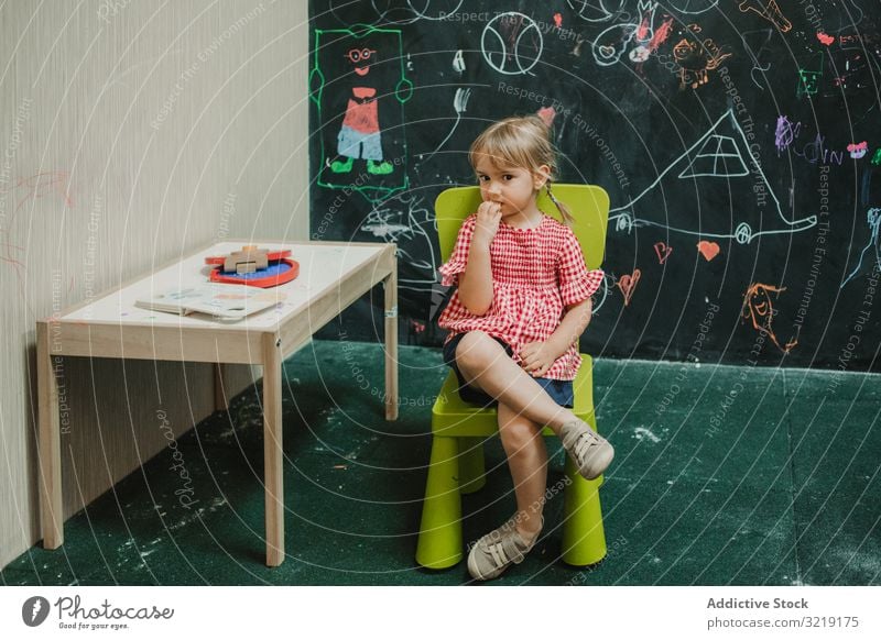 Girl sitting on light green chair with crossed legs child girl adorable childhood creative little creativity education fun kid learning play happy cute colorful