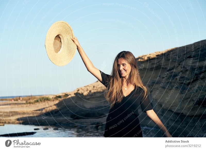 Cheerful woman holding hat in air model cheerful beach nature smile stylish young attractive beautiful pretty summer female natural elegant posing travel