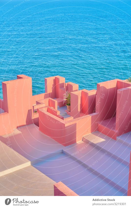 Pink wall construction against blue sea pink architecture building geometric structure urban facade abstract sky maze public exterior innovation modern city