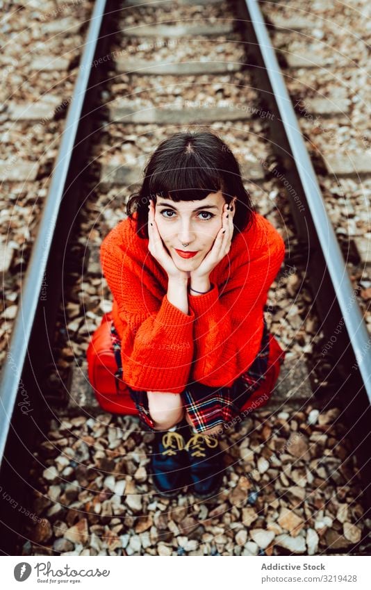 Woman sitting on sleepers in middle of railway woman railroad suitcase red travel stylish green female luggage nature beautiful bag waiting freedom alone trip