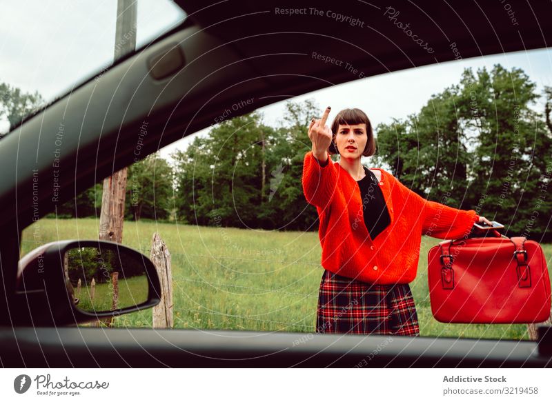 Woman in red sweater gesturing near car on road woman auto stop suitcase travel stylish female luggage nature beautiful bag fashion waiting freedom alone smile
