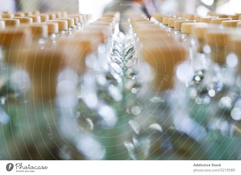 Rows of unopened glass bottles row blurred lid daylight shiny drink alcohol modern distilled traditional beverage exotic technology industrial factory